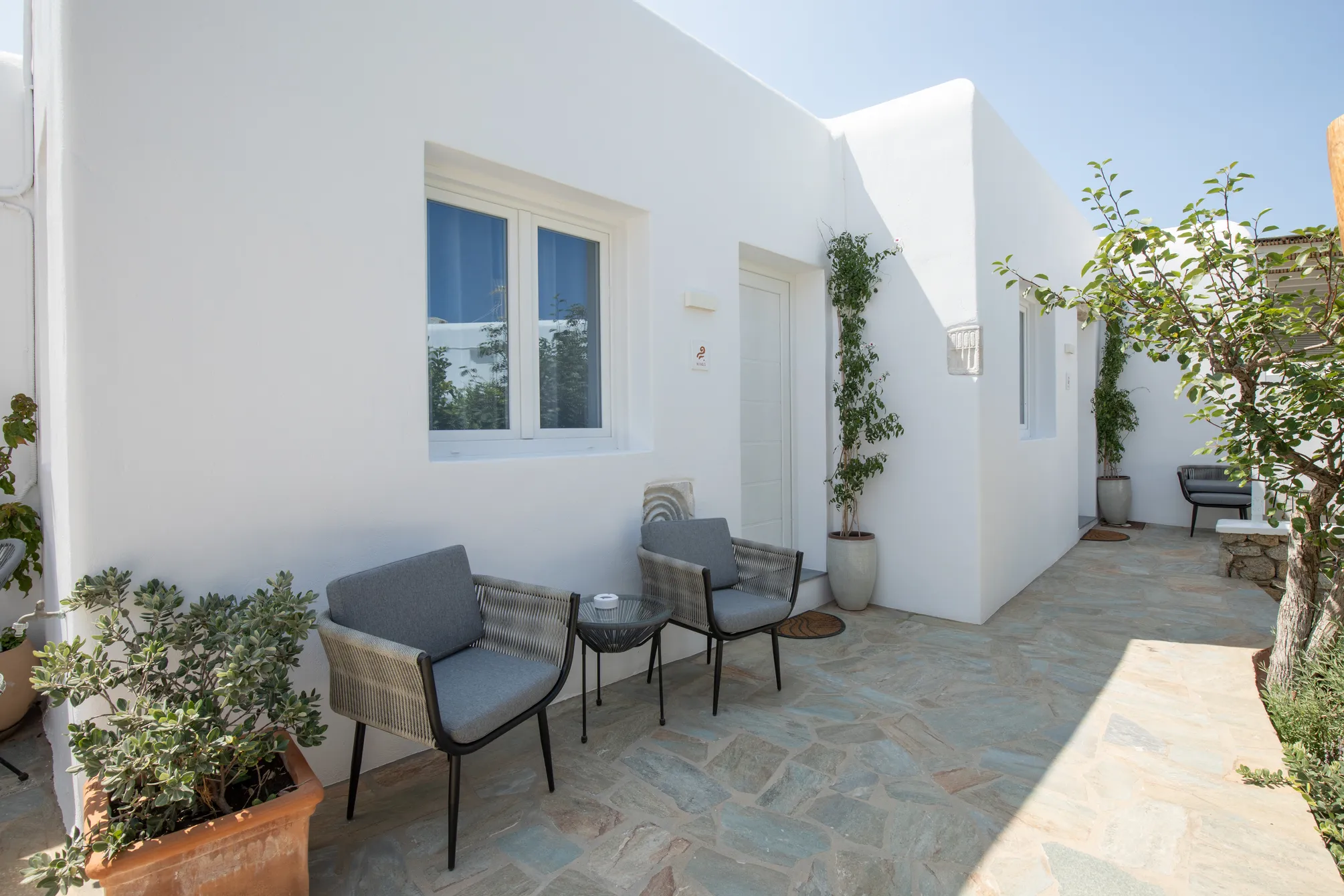 Terrace with grey armchairs under a lemon tree
